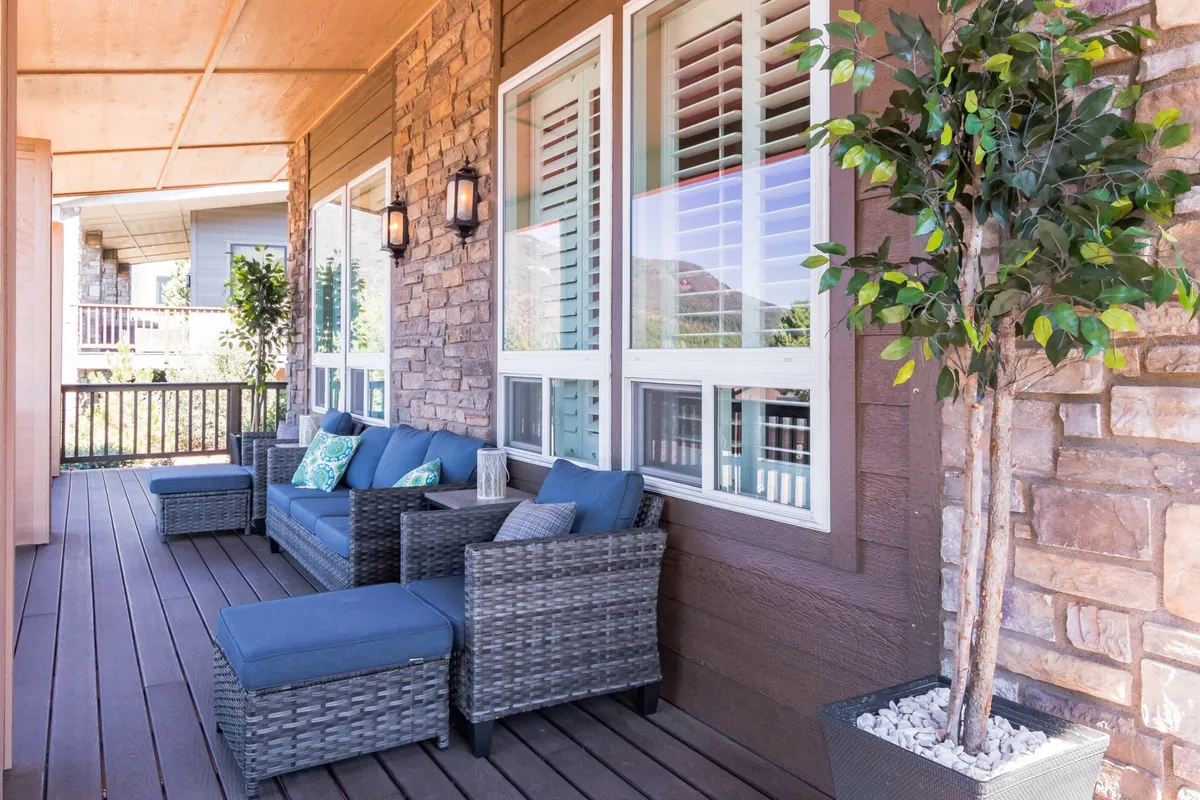 This image features a comfortable outdoor seating area with decorative cushions and a potted plant, set against a tranquil backdrop of natural surroundings. The space is designed for relaxation, with cozy furnishings that invite guests to enjoy the fresh air, sunrise views, or intimate moments together.