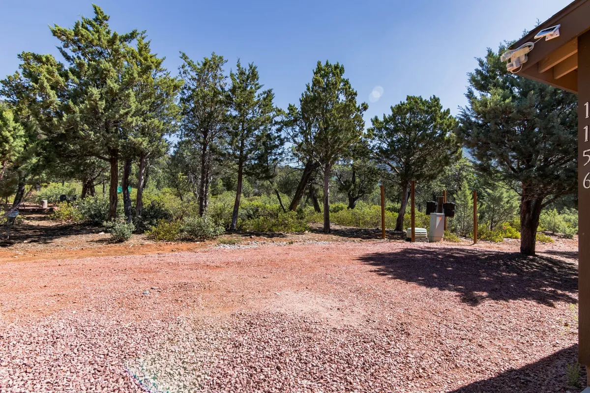 A tranquil scene with trees, a gravel pathway, and distant hills under soft light. The setting exudes a peaceful, natural ambiance ideal for walks, birdwatching, and picnicking, emphasizing the outdoor experiences available nearby.
